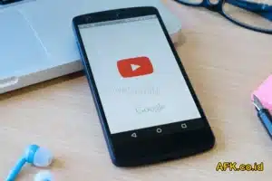 handphone menampilkan logo youtube di atas meja